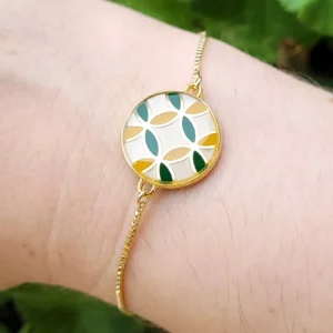 Bracelet réglable avec un intercalaire rond, blanc, vert et doré.