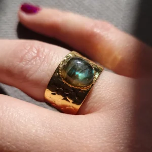 Bague martelée, légèrement ajustable, avec un petit cabochon en labradorite, de couleur verte et bleue.