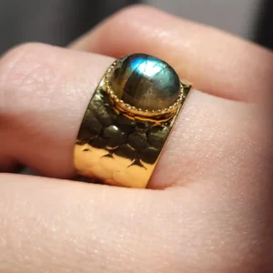 Bague martelée, légèrement ajustable, avec un petit cabochon en labradorite, de couleur verte et bleue.