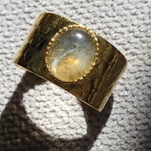 Bague martelée, légèrement ajustable, avec un petit cabochon en labradorite, de couleur verte et bleue.