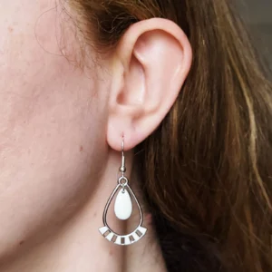 Boucles d'oreilles pendantes très légères, de couleur argentées et blanches en forme de goutte avec une pampille blanche au centre.