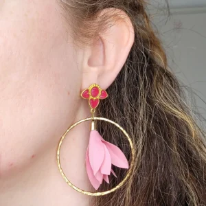 Boucles d'oreilles pendantes avec des supports en formes de 3 coeurs colorés en fuschia avec résine Epoxy vitrail et dorés. Ces supports ont un anneau martelé et un pompon en imitation satin de couleur rose à l'intérieur.