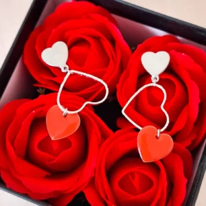 Boucles d'oreilles pendantes avec un coeur ciselé argenté et des sequins en forme de coeur corail