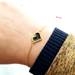 Bracelet réglable avec un coeur doré noir en pixel.