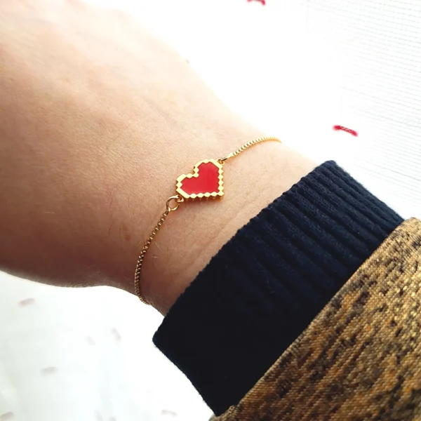 Bracelet réglable avec un coeur doré rouge en pixel.