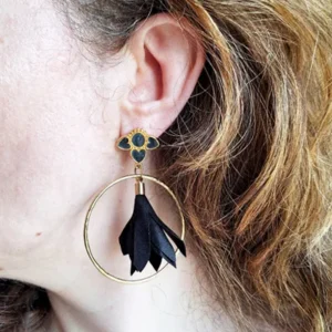 Boucles d'oreilles pendantes avec des supports en formes de 3 coeurs colorés en noir nacré et dorés. Ces supports ont un anneau martelé et un pompon en imitation satin de couleur noir à l'intérieur.